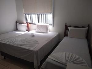 Rolim de MouraCrystal Palace Hotel的带窗户的客房内设有两张单人床。