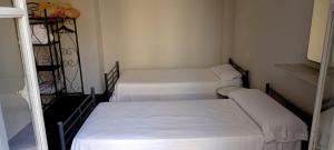 阿利坎特Old Center Inn Alicante的小客房内的三张床,配有白色床单