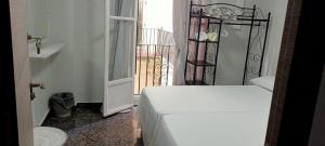 阿利坎特Old Center Inn Alicante的一间卧室设有一张床,并有通往阳台的门