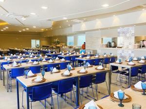 奥林匹亚Apartamento no Solar das Águas Park Resort的一个带桌子和蓝色椅子的用餐大厅
