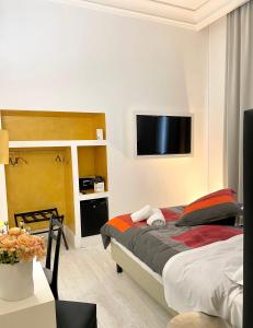 雷焦卡拉布里亚XENIA LUXURY ROOMS的一间卧室配有一张床和一台平面电视