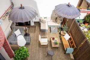 滨海图维列TOWNHOUSE TROUVILLE - Appart'Hotel & Studios的享有带两把遮阳伞的天井的空中景致