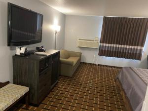 法里巴尔Faribault Hometown Inn & Suites的酒店的客房配有平面电视和沙发。
