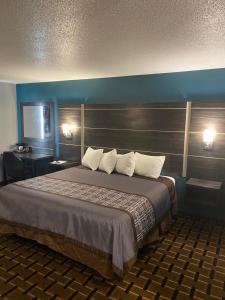 法里巴尔Faribault Hometown Inn & Suites的一张大床,位于酒店带两盏灯的房间
