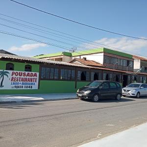 阿拉鲁阿马Pousada Lagoa de Araruama的停在大楼前的街道上的汽车