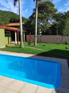 弗洛里亚诺波利斯Tiny House Perfeita para Casais的棕榈树屋前的游泳池