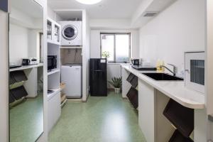 金泽Granrina Kanazawa - Female only apartment hotel的厨房配有白色的柜台和黑色的冰箱。