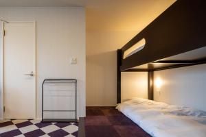 金泽Granrina Kanazawa - Female only apartment hotel的一间卧室设有一张双层床和一张可调节的地板。