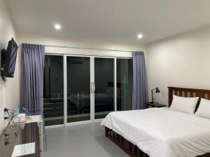 甲米镇第九楼旅舍的一间卧室设有一张床和一个滑动玻璃门