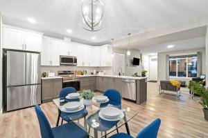 埃德蒙顿Upscale Urban Oasis- Stylish Townhome Getaway-Comfort for Family, Work and Longer Visits的厨房以及带桌子和蓝色椅子的用餐室。