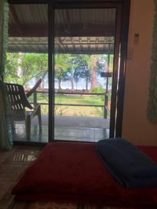 Ko Sukon苏孔安达曼海滩度假村的卧室配有床、椅子和窗户。
