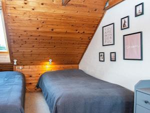罗莫柯克比Holiday home Rømø CXXV的一间卧室设有两张床和木制天花板