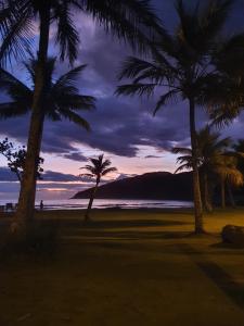瓜鲁雅Pé na Areia Sons do Mar的日落时分在海滩上种植的棕榈树