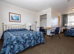 桑德贝Relax Motel的酒店客房带一张床、一张桌子和椅子