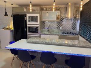 卡斯卡韦尔Casa para Show Rural Flat Sobrado的厨房配有白色的柜台和蓝色的椅子