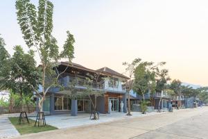 Ban Nam ChamHappy Land Residence的树荫街道边的建筑