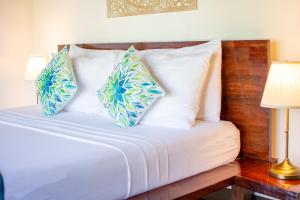 爱妮岛卡德捞度假酒店及餐厅的一张带蓝色和白色枕头的床