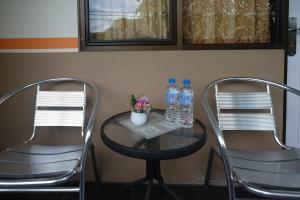 美娜多RedDoorz @ Jalan Pramuka Manado的2把椅子和2瓶桌子水