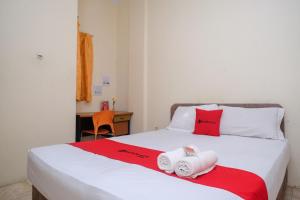 美娜多RedDoorz near Jalan Wolter Monginsidi Manado的一间卧室配有带毛巾的床