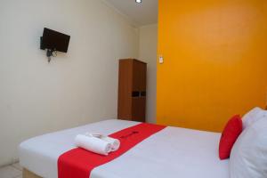 美娜多RedDoorz near Jalan Wolter Monginsidi Manado的一间卧室配有一张床,上面有两条毛巾