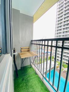 马尼拉Cozy 1Br with Netflix & Balcony Pool View Condo的阳台设有木桌和游泳池。