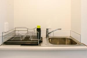 瓦纳卡Wanaka Riverside 1 Bedroom Apartment的厨房水槽旁的碗碟干燥架