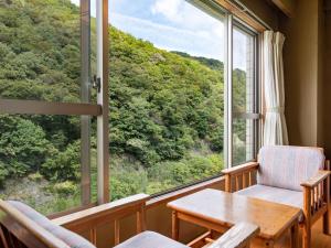 高松辛卡巴卡瓦观光酒店的客房设有桌椅和大窗户。