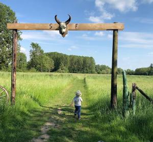 AuthouilletLa Ferme des Isles的一只幼童在木十字架上带着一头牛行走