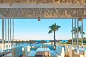 阿依纳帕So Nice Club Resort的配有桌椅的餐厅享有海滩美景