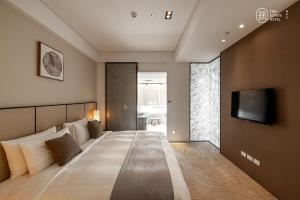 淡水蘊泉庄 Yun Estate Hotel的一间卧室设有一张大床,墙上设有一台电视机