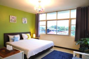华欣Baan Nilawan Hua Hin Hotel的一间卧室设有一张床和一个大窗户