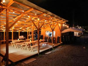 东近江市リバーサイドグランピングNuts的夜间带桌椅的木制凉亭