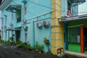 PanikiRedDoorz near Politeknik Manado的街道边的蓝色和黄色建筑