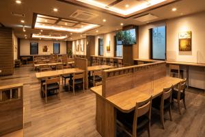 松山Hotel Route Inn Matsuyama -Katsuyama Dori-的用餐室配有木桌和椅子