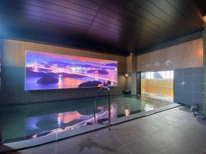 松山Hotel Route Inn Matsuyama -Katsuyama Dori-的游泳池上方墙上的大电视