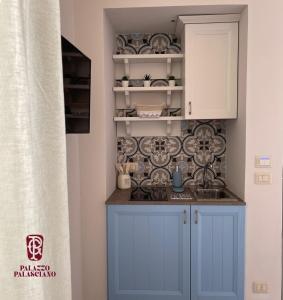 莫诺波利Palazzo Palasciano的厨房配有蓝色橱柜和墙上的盘子
