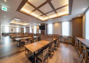 IzumiHotel Route Inn Osaka Izumifuchu的用餐室配有木桌和椅子
