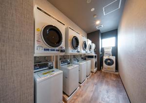 IzumiHotel Route Inn Osaka Izumifuchu的洗衣房配有一排洗衣机和烘干机