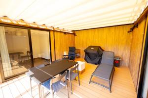 IsumiISUMI Glamping Resort ＆Spa SOLAS的一个带桌椅的甲板和帐篷