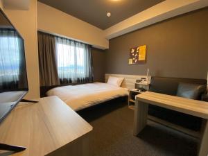 IzumiHotel Route Inn Osaka Izumifuchu的配有一张床和一台平面电视的酒店客房