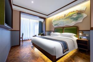 杭州时光漫步S酒店（杭州西湖店）的卧室配有一张大床,墙上挂有绘画作品