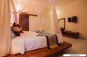 蓝梦岛Warisan Villa By Reccoma的一间卧室配有一张带天蓬的床