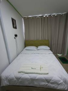 哥打京那巴鲁OYO Home 90723 Green Leaf Guest Lodge Kk的床上有一条白色毛巾