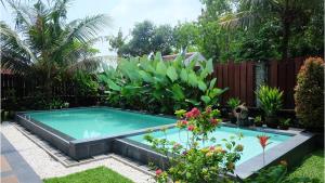 斯勒曼Villa Prambanan Jogja with Private Swimming Pool by Simply Homy的花园内的游泳池
