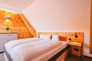 班贝格安德烈斯酒店的卧室配有白色的床和木墙