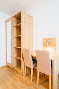 班贝格安德烈斯酒店的一张带两把椅子的木桌和书架