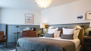 葱仁谷Le Fitz Roy, a Beaumier hotel的一间卧室配有一张大床和一个吊灯。
