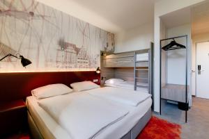 莱比锡Campanile Leipzig Halle Airport的一间卧室配有一张大床和一张双层床。