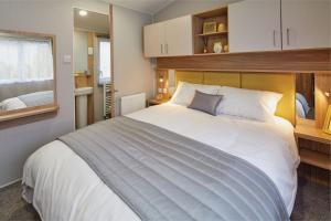 梅布尔索普Golden Sands Retreat的卧室设有一张白色大床和一扇窗户。