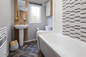 梅布尔索普Golden Sands Retreat的带浴缸、盥洗盆和卫生间的浴室